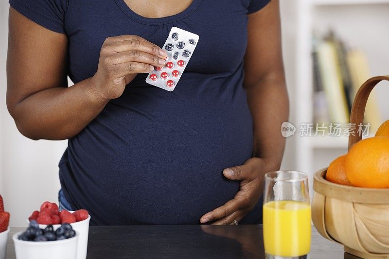 怀孕的非洲裔美国妇女持有药物/药丸/药片的特写